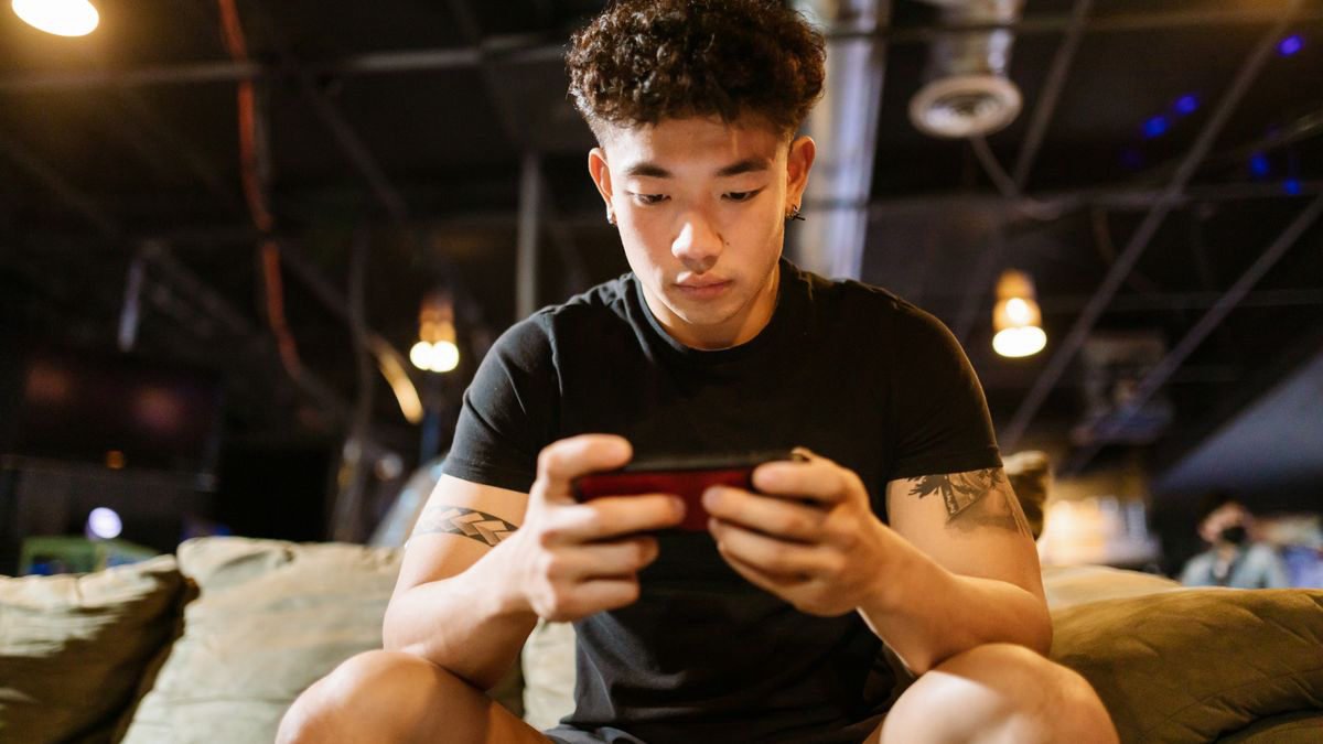 Man focused on a game on his smartphone at home