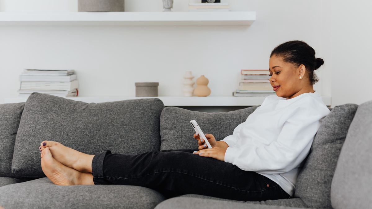 Woman browsing on her smartphone in a cosy living room