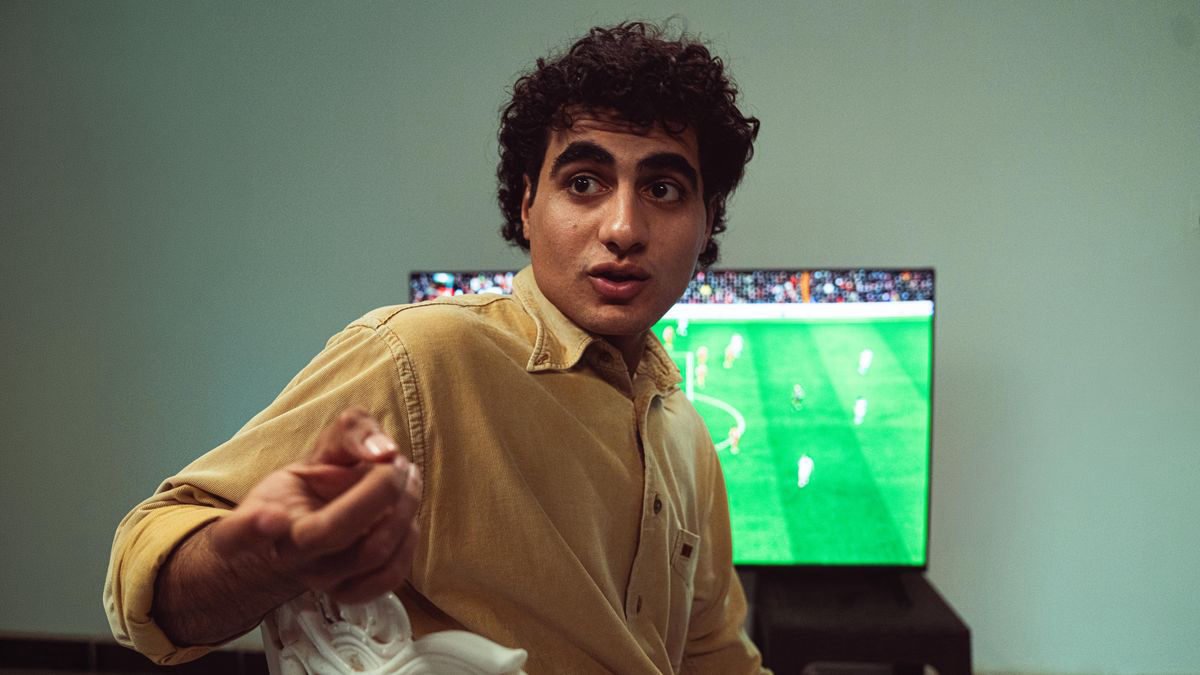 Man watching a soccer game on television at home