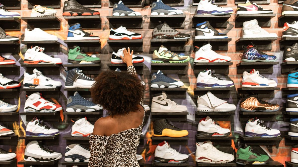 Woman browsing sneakers on shelves in a shoe store