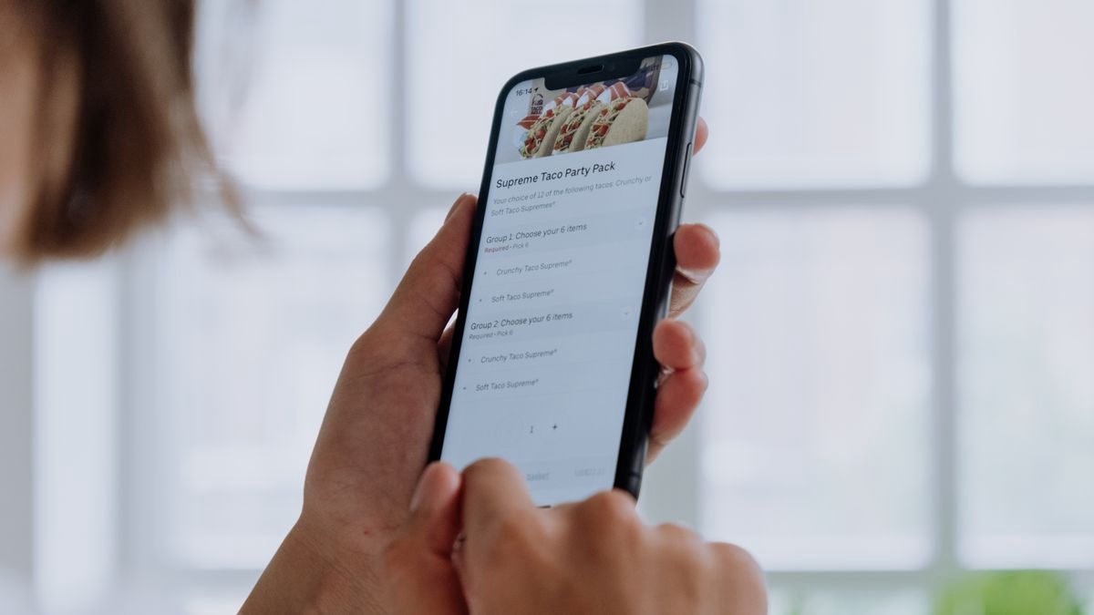 Hands using a smartphone to order food through an app