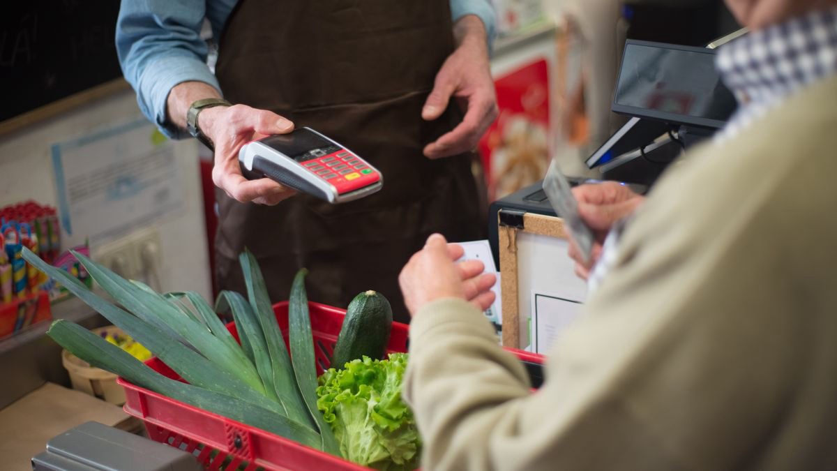 Customer paying for groceries at a supermarket checkout