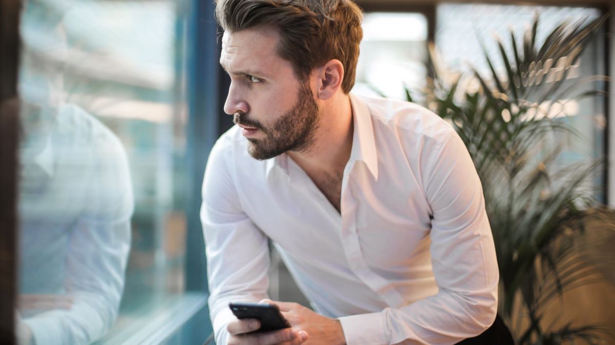 Thoughtful man reading something on his smartphone