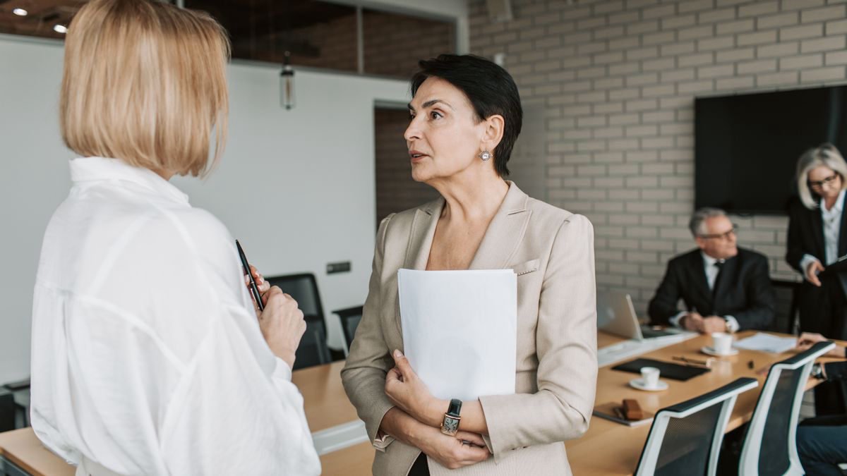 Two businesswomen in conversation during an office meeting