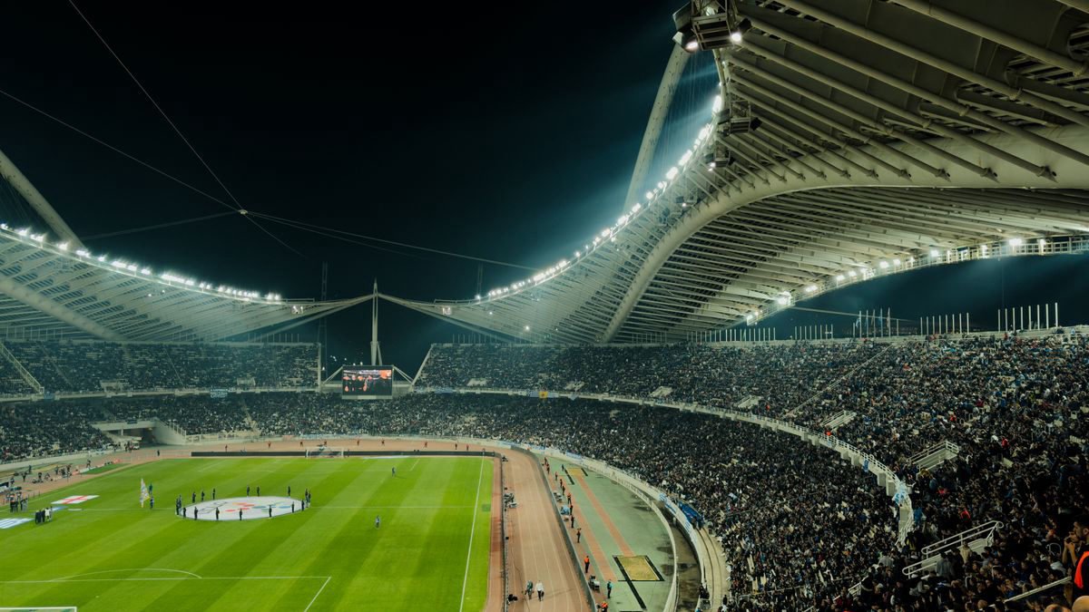 Crowded soccer stadium under bright lights at night