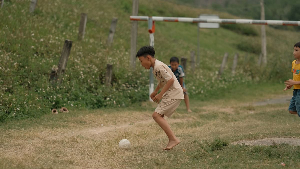 Young boys playing soccer on a grassy field