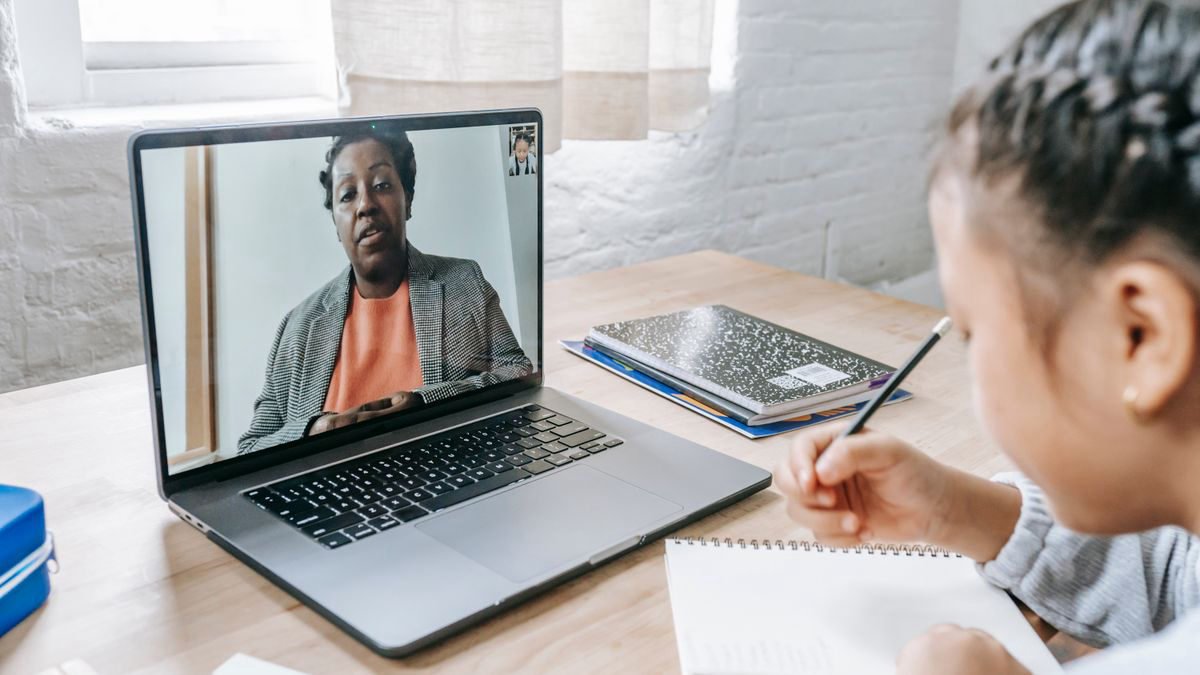 Girl studying at home with a tutor on a laptop video call