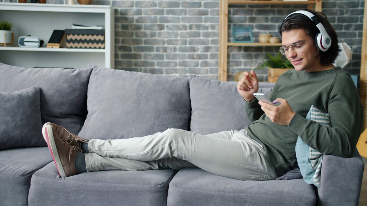 Man listening to music on headphones while using his smartphone