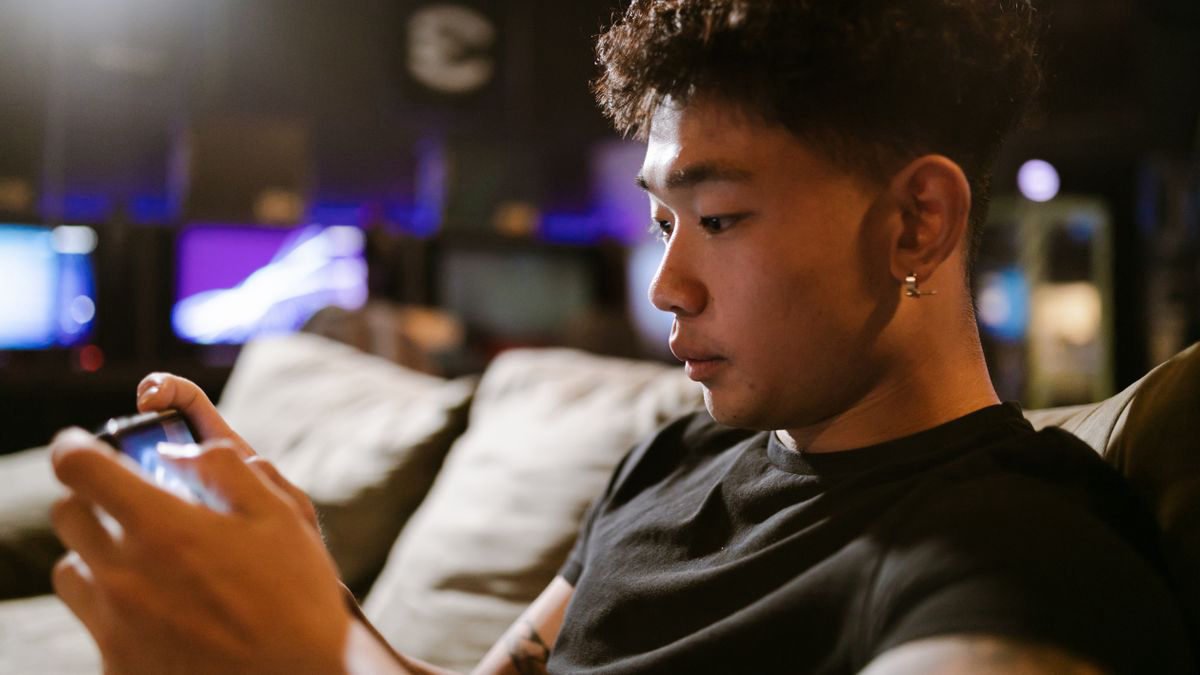 Young man immersed in a game on his smartphone indoors