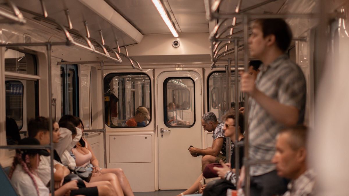 People on a subway train using their phones