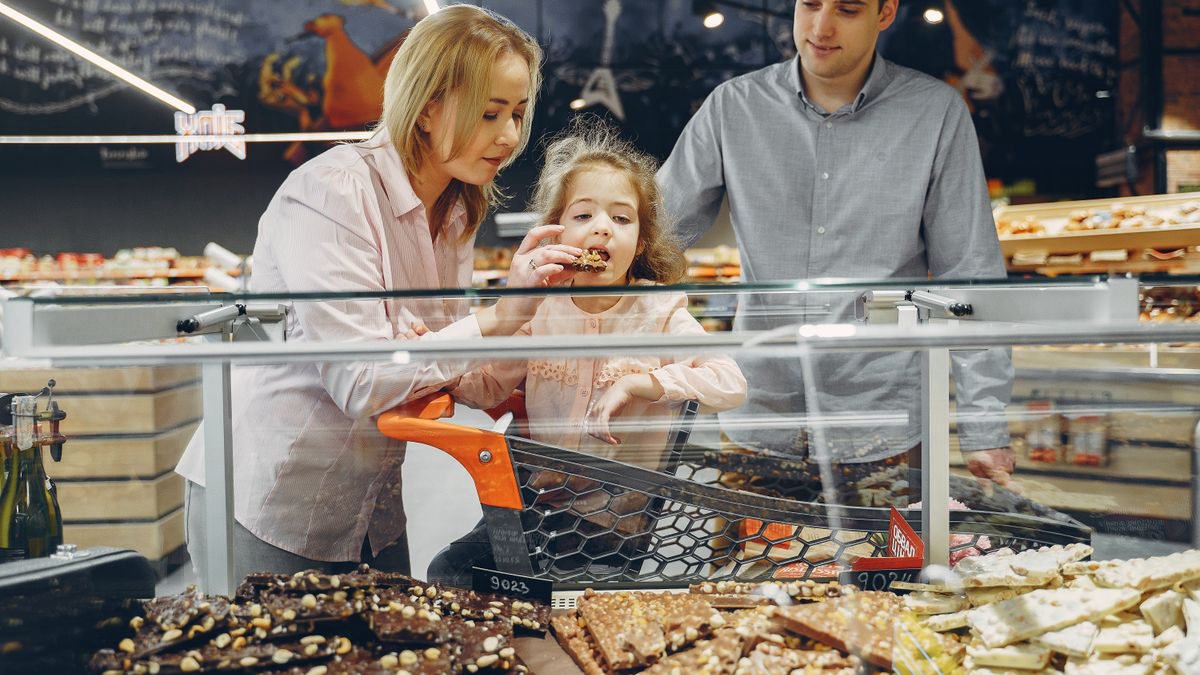 Family sampling chocolates together in a supermarket