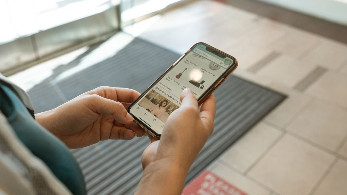 Close-up of hands holding a smartphone with a shopping app open