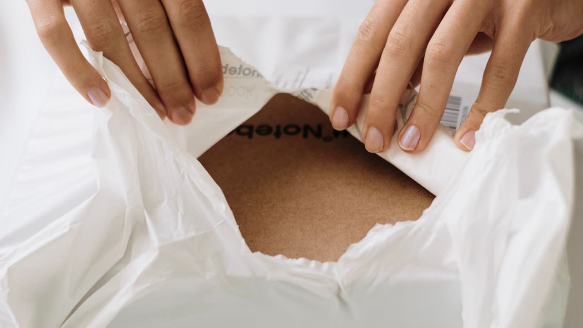 Hands carefully opening a white package at home