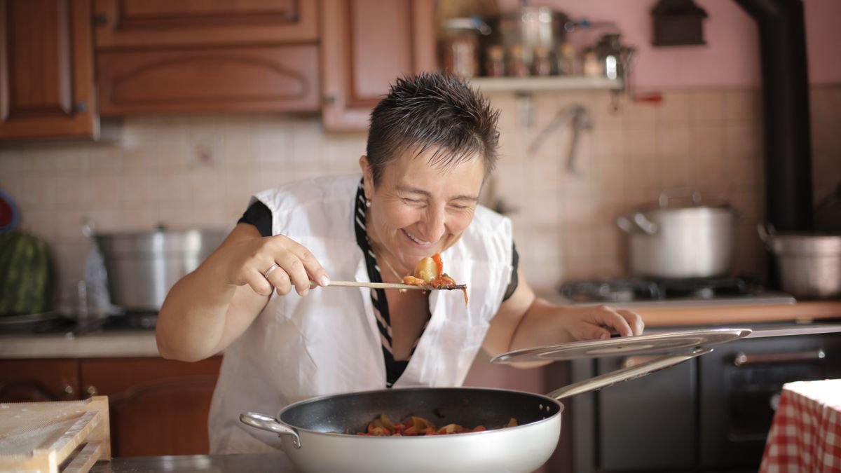 Smiling woman enjoying the aroma of a freshly cooked meal at home