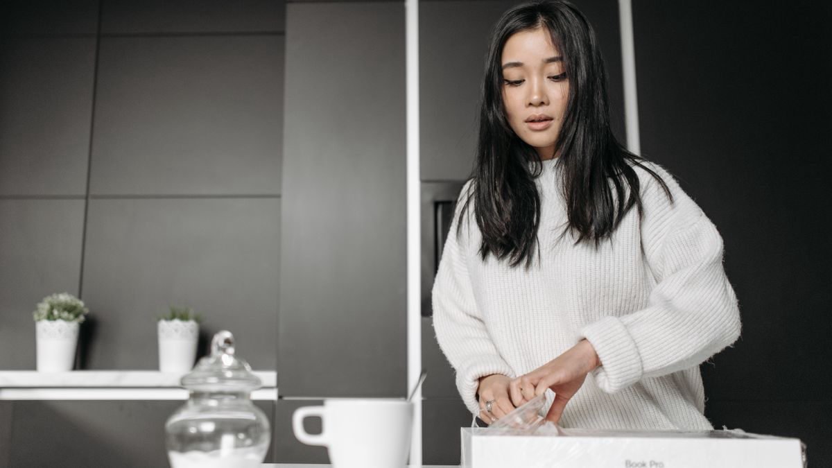 Young woman opening a box in a modern kitchen