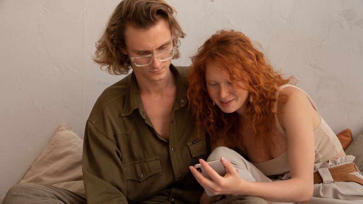 Couple in casual clothes browsing a smartphone together