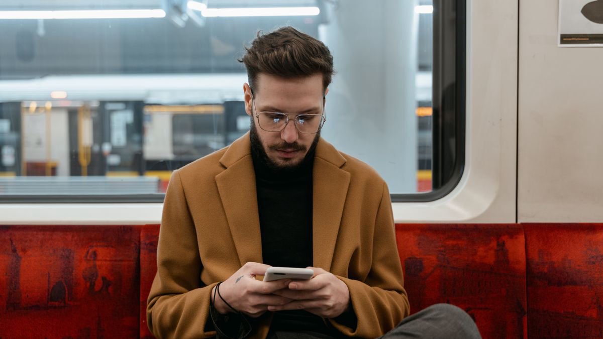 Young man using his smartphone on an underground train