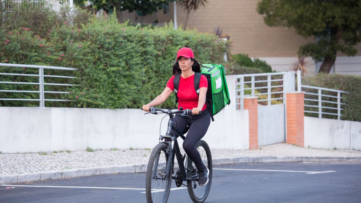 A courier in a red jacket delivering food by bicycle
