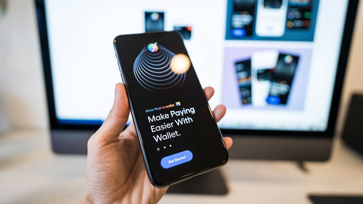 A hand holding a smartphone showing a digital wallet app
