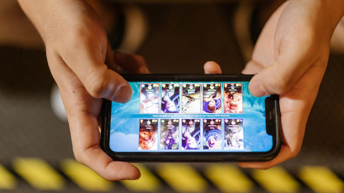 Close-up of hands holding a smartphone and playing a mobile game