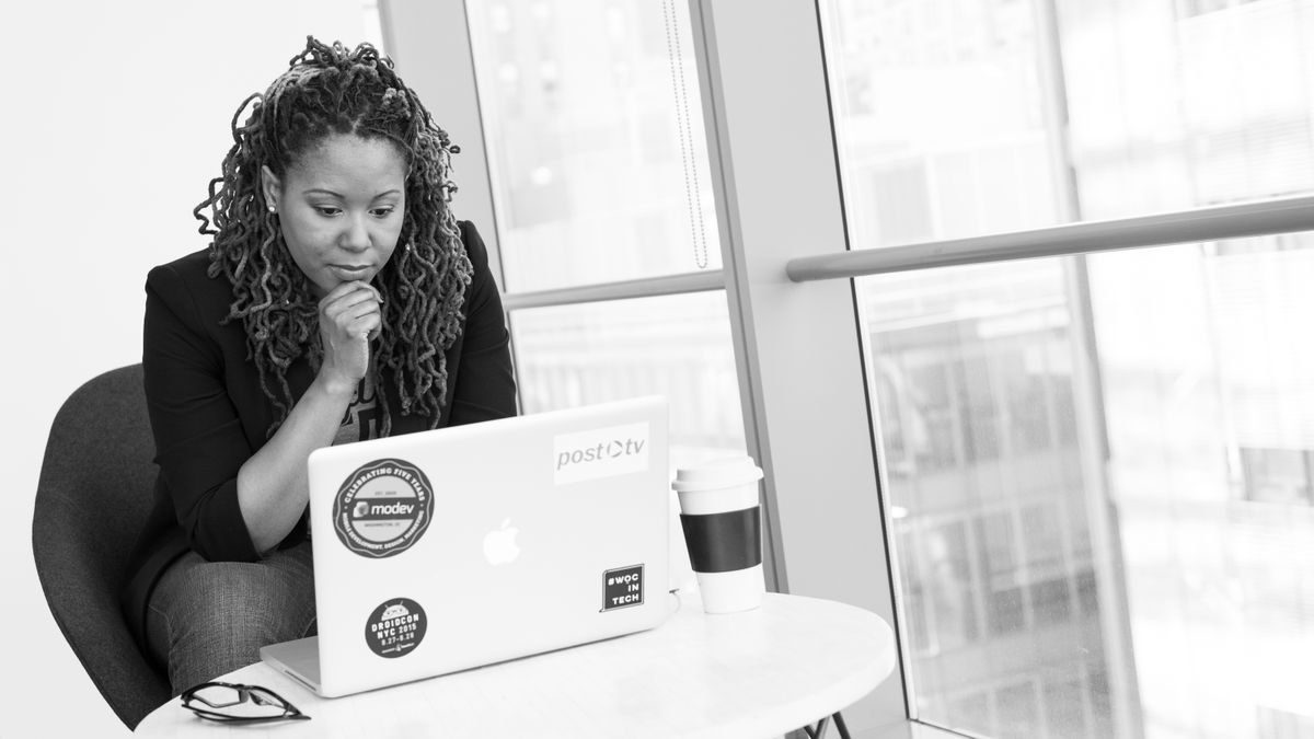 A woman at her laptop focused on a spreadsheet