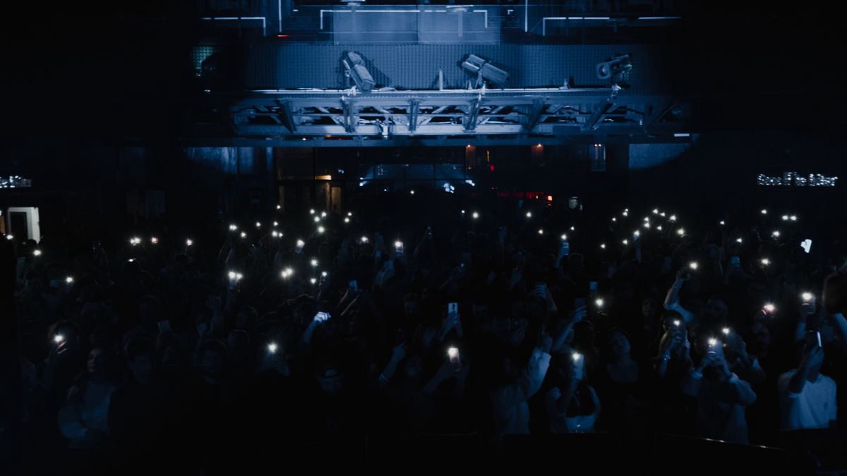 Concert crowd holding up smartphones during a live show