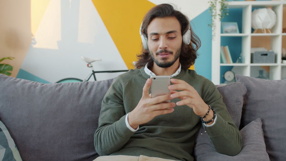 Young man with headphones relaxing while using his smartphone