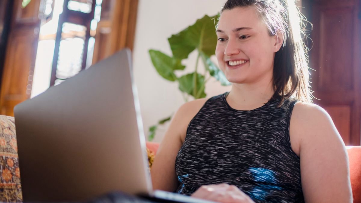 Smiling woman using her laptop in a comfortable home setting