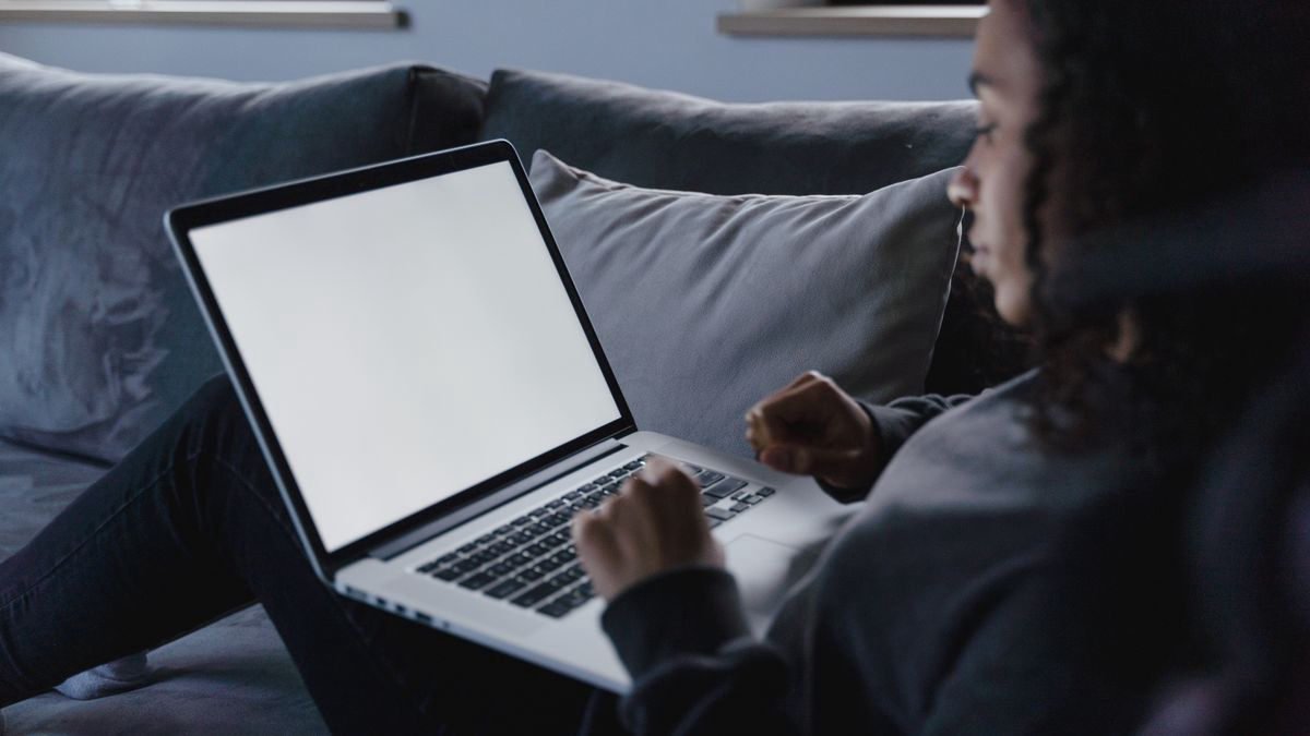 Young woman working on her laptop in a cosy living room